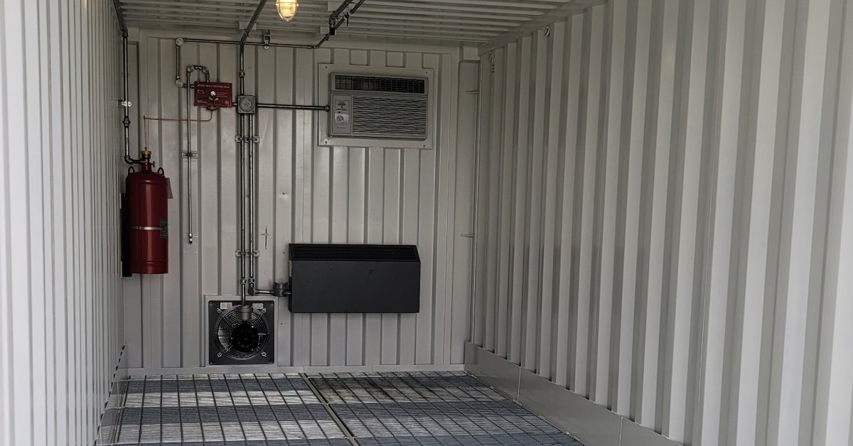 Climate-controlled hazmat storage container featuring ventilation systems, safety equipment, and durable grated flooring.