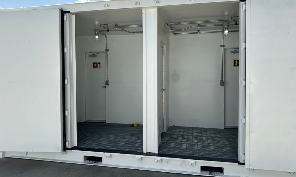 The side of a white storage container with two doors on it wide open. The inside of the containers are empty.